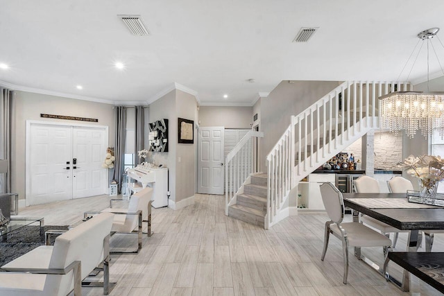 foyer featuring light hardwood / wood-style flooring, a notable chandelier, and crown molding