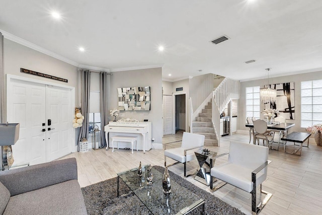 living room with light hardwood / wood-style floors, crown molding, and a chandelier