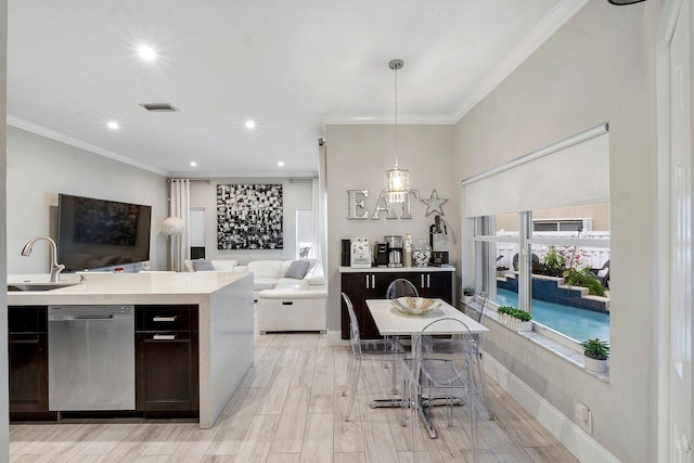 kitchen featuring stainless steel dishwasher, crown molding, sink, pendant lighting, and light hardwood / wood-style flooring