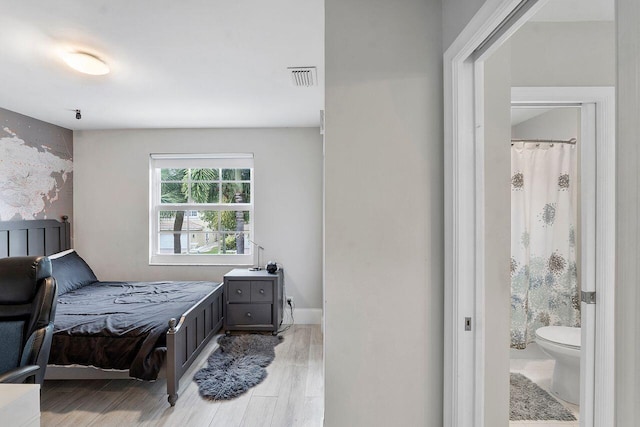 bedroom featuring ensuite bathroom and light hardwood / wood-style floors