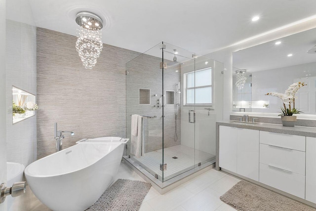 bathroom featuring plus walk in shower, tile patterned flooring, vanity, and an inviting chandelier