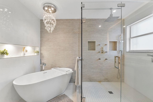 bathroom with separate shower and tub, tile patterned floors, tile walls, and an inviting chandelier