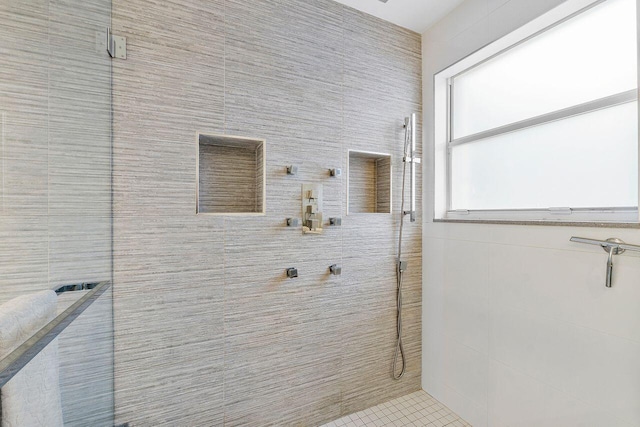 bathroom with tiled shower and tile patterned floors