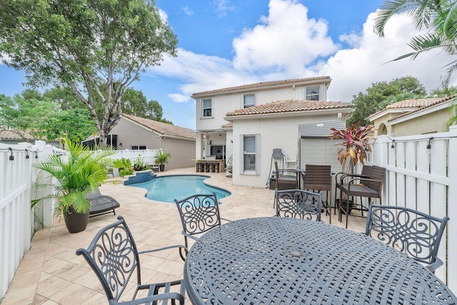 rear view of house with a fenced in pool, exterior bar, and a patio