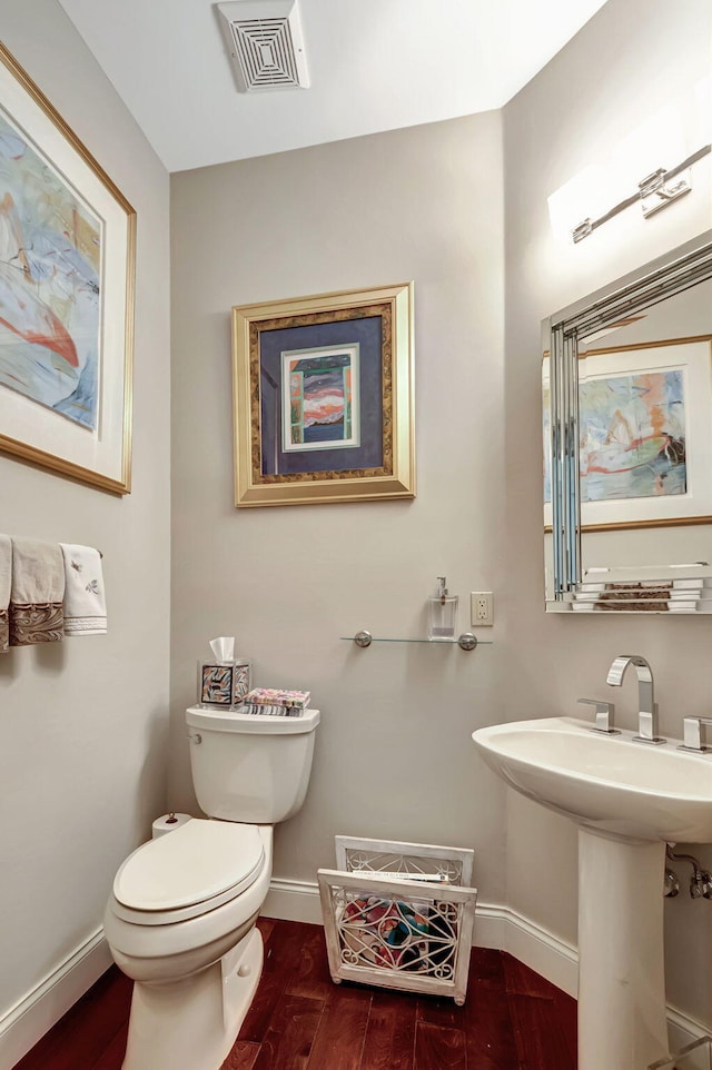 bathroom featuring hardwood / wood-style flooring, toilet, and sink