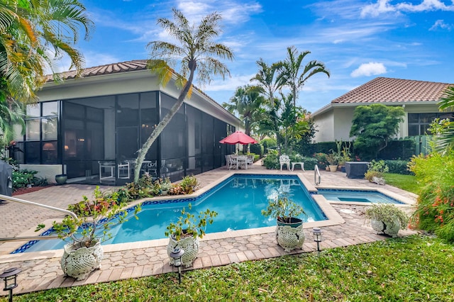 view of pool featuring a sunroom, a patio area, and an in ground hot tub