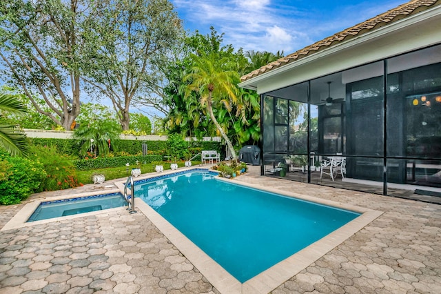 view of pool featuring a sunroom, a patio area, and an in ground hot tub