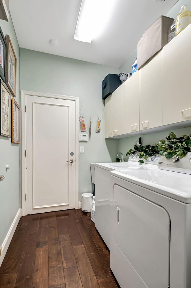 laundry room featuring cabinets, washer and dryer, and dark wood-type flooring