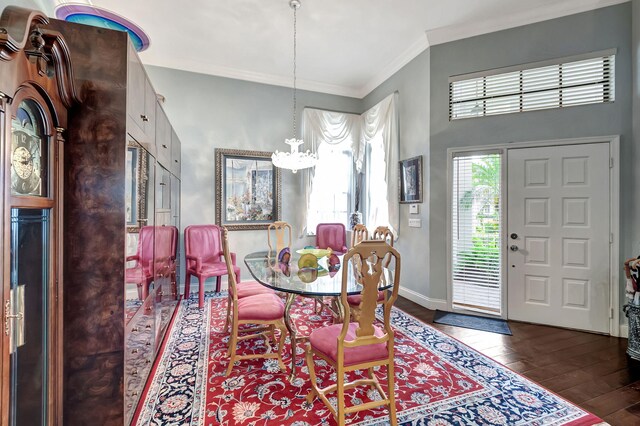 dining space with a notable chandelier, crown molding, and dark wood-type flooring