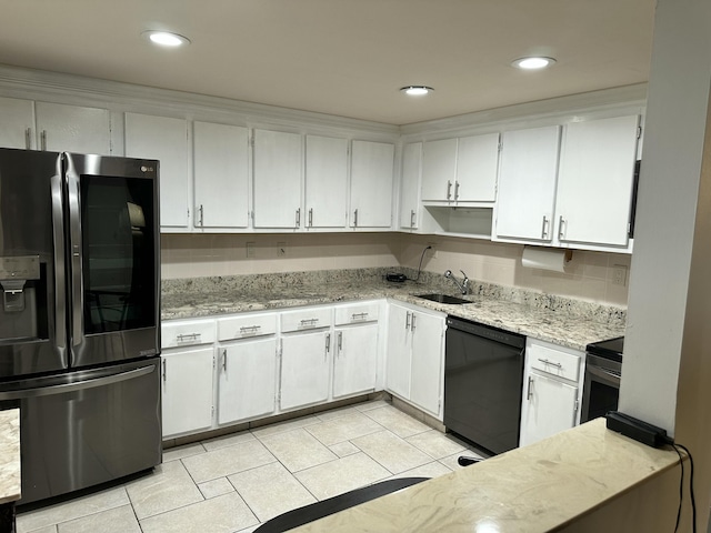 kitchen featuring light tile patterned flooring, sink, white cabinetry, appliances with stainless steel finishes, and backsplash