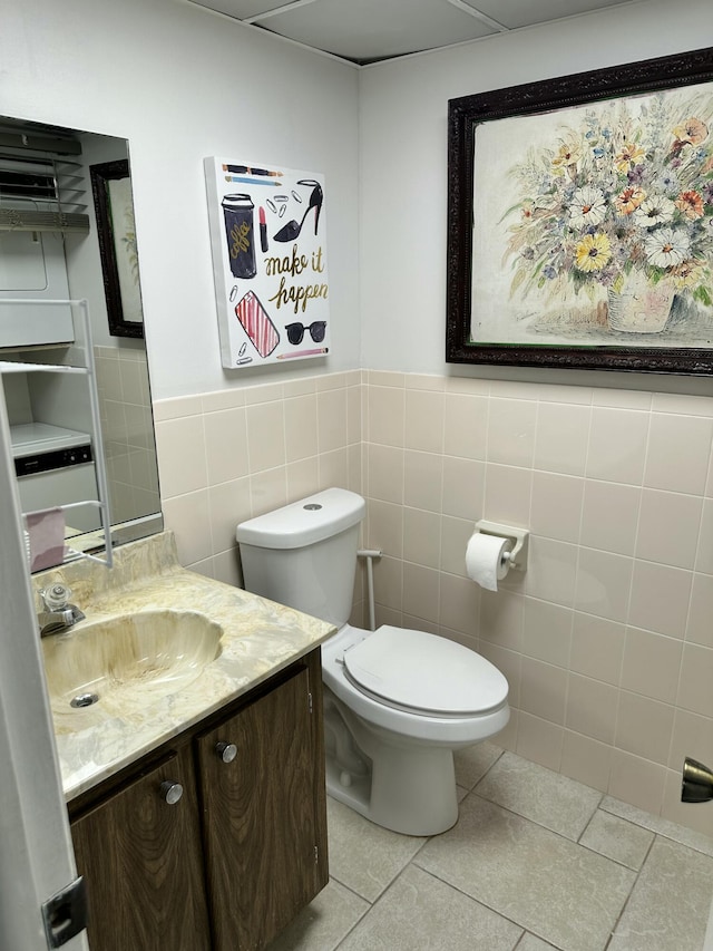 bathroom with vanity, tile walls, tile patterned floors, and toilet