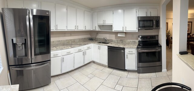 kitchen with white cabinetry, black fridge with ice dispenser, and sink