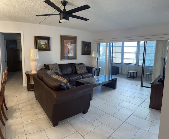 tiled living room with ceiling fan and a textured ceiling