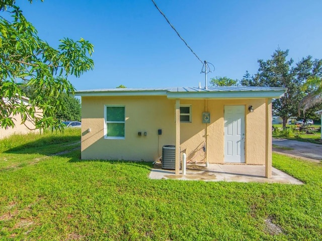 rear view of house with a yard and cooling unit