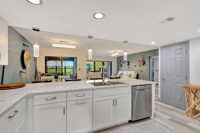 kitchen featuring dishwasher, white cabinetry, hanging light fixtures, and sink