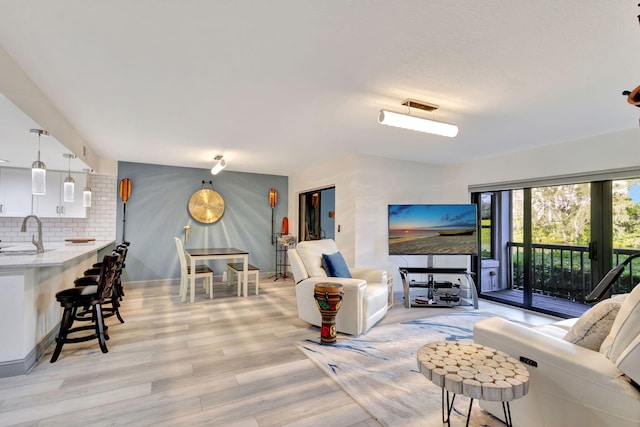 living room with sink and light hardwood / wood-style flooring