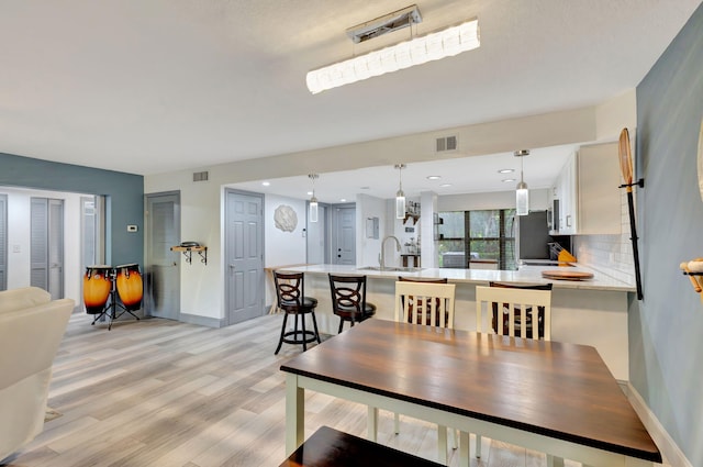 dining room with light hardwood / wood-style floors and sink