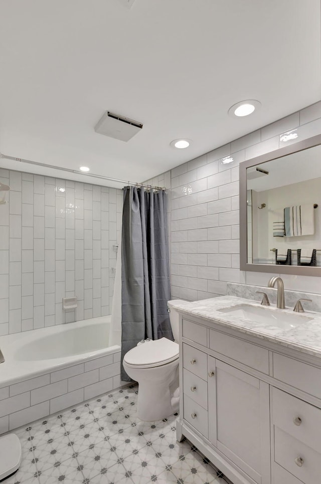 full bathroom with vanity, shower / bath combination with curtain, tile walls, and toilet