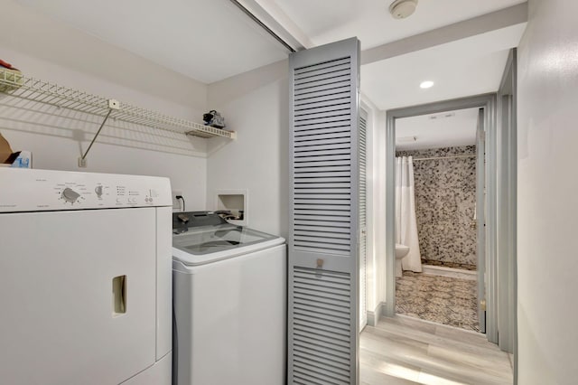 laundry area with light hardwood / wood-style floors and separate washer and dryer