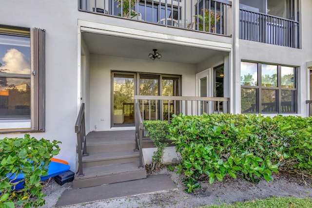 view of exterior entry with a balcony