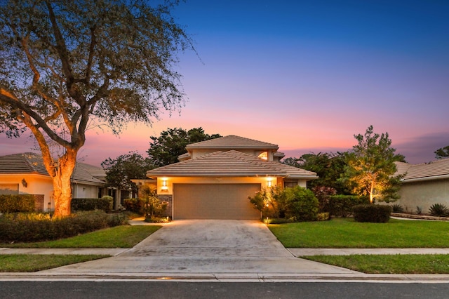 view of front of home with a garage and a lawn