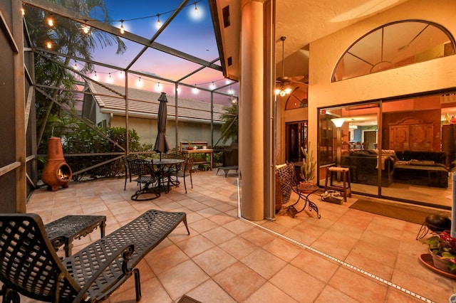 patio terrace at dusk featuring glass enclosure