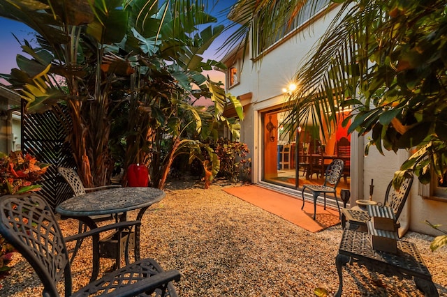 yard at dusk featuring a patio area