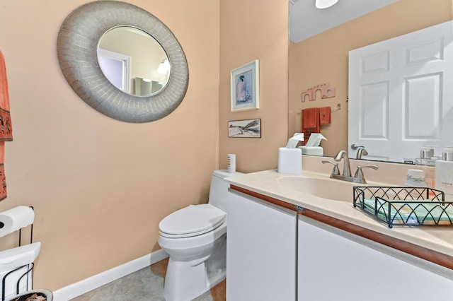 bathroom with tile patterned flooring, vanity, and toilet