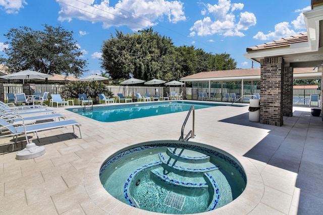 view of swimming pool featuring a patio area and a hot tub