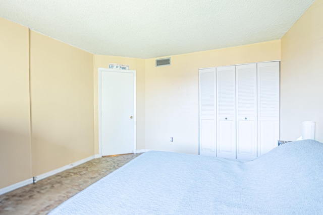 bedroom with carpet, a textured ceiling, and a closet