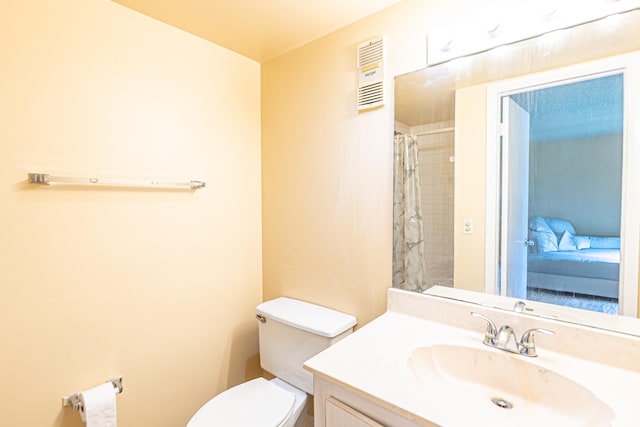 bathroom with walk in shower, vanity, and toilet