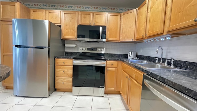 kitchen featuring decorative backsplash, light tile patterned floors, stainless steel appliances, and sink