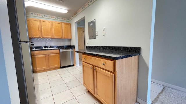 kitchen with backsplash, light tile patterned floors, sink, and appliances with stainless steel finishes