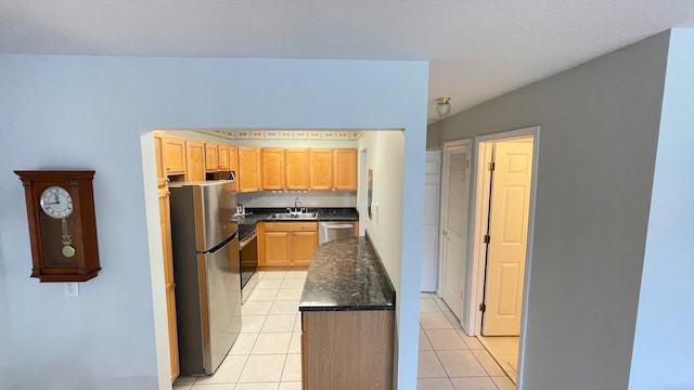 kitchen featuring appliances with stainless steel finishes, light tile patterned floors, and sink