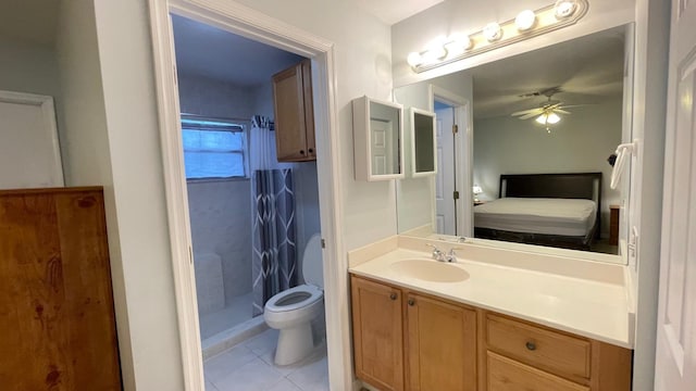 bathroom featuring vanity, a shower, tile patterned flooring, ceiling fan, and toilet