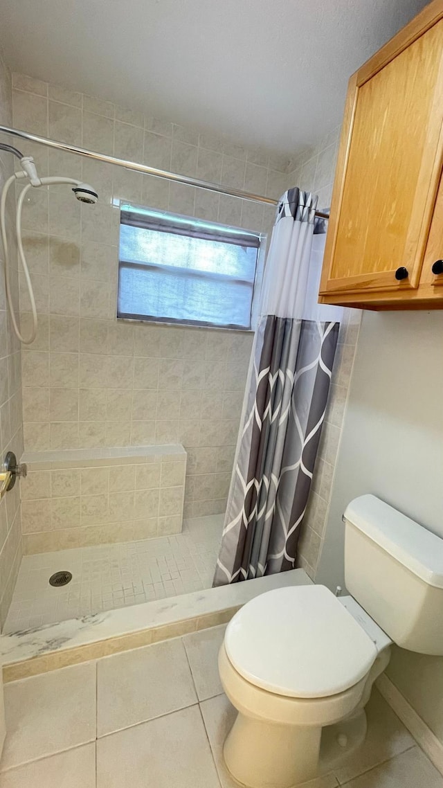 bathroom featuring toilet, tile patterned flooring, and walk in shower