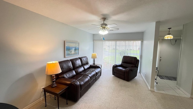 living room featuring ceiling fan, light colored carpet, and a textured ceiling