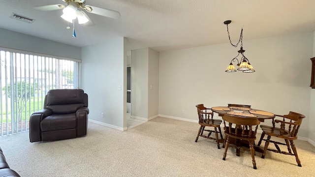 carpeted dining space featuring a textured ceiling and ceiling fan