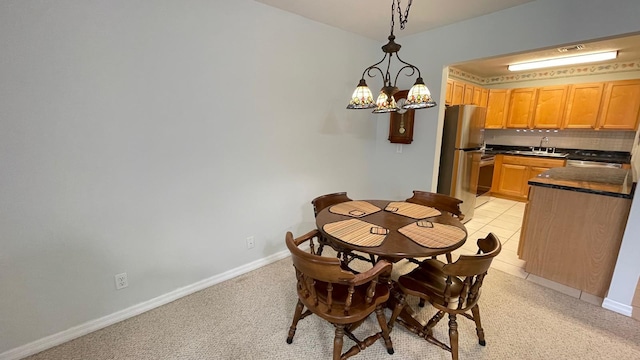 dining area featuring a notable chandelier, light tile patterned floors, and sink