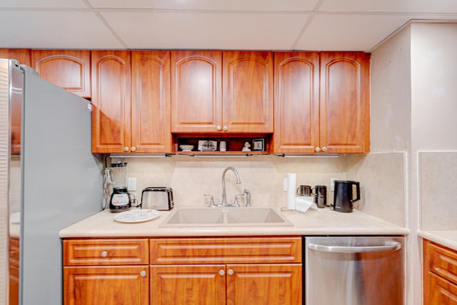 kitchen featuring tasteful backsplash, a paneled ceiling, sink, and stainless steel appliances