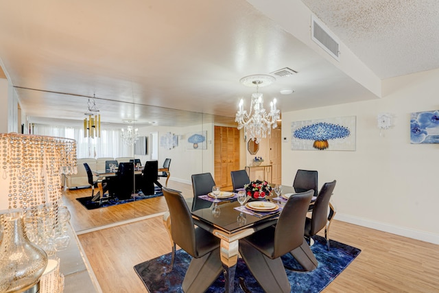 dining area featuring an inviting chandelier, a textured ceiling, and hardwood / wood-style flooring