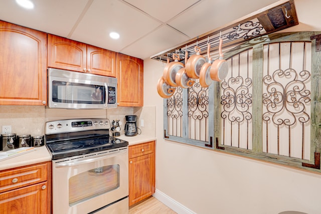 kitchen featuring decorative backsplash, light hardwood / wood-style floors, and appliances with stainless steel finishes