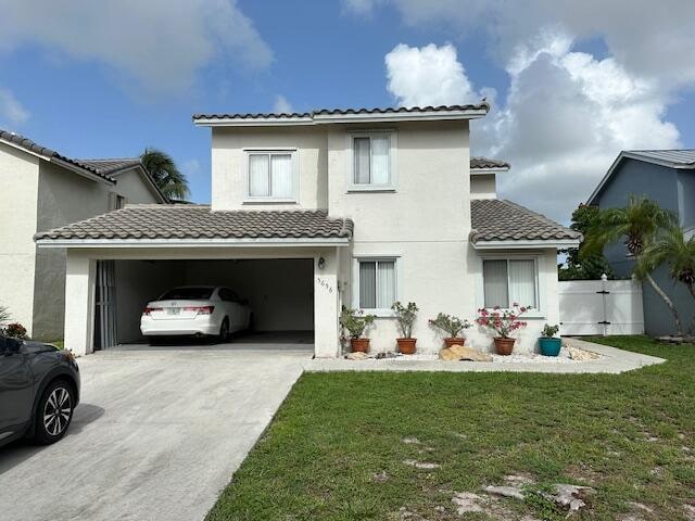 mediterranean / spanish-style home with a garage and a front lawn