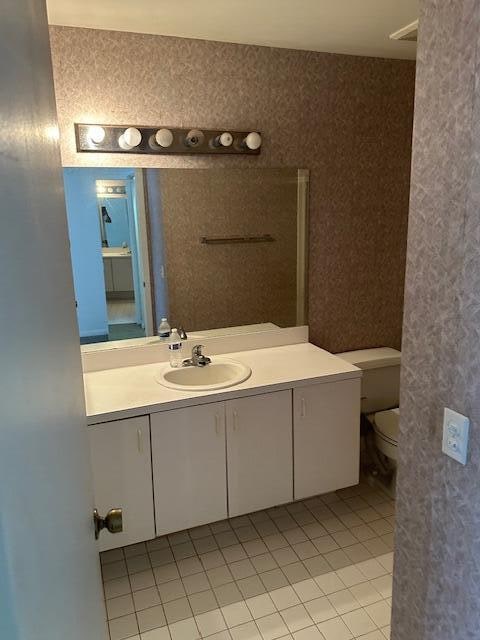 bathroom featuring tile patterned flooring, vanity, and toilet