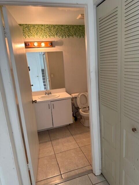 bathroom with tile patterned flooring, vanity, and toilet