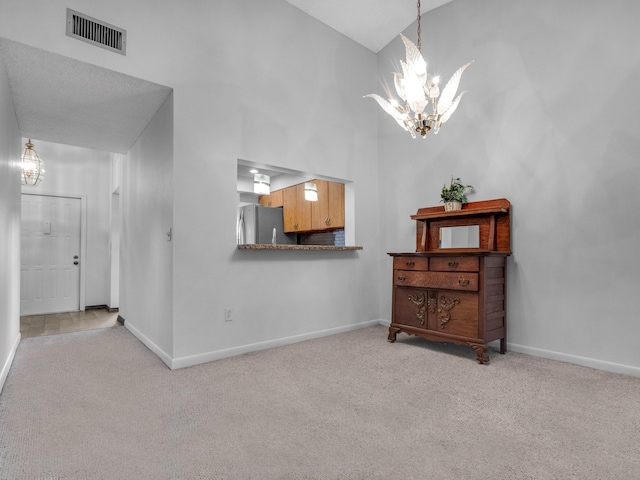 interior space with carpet floors, baseboards, visible vents, and a notable chandelier