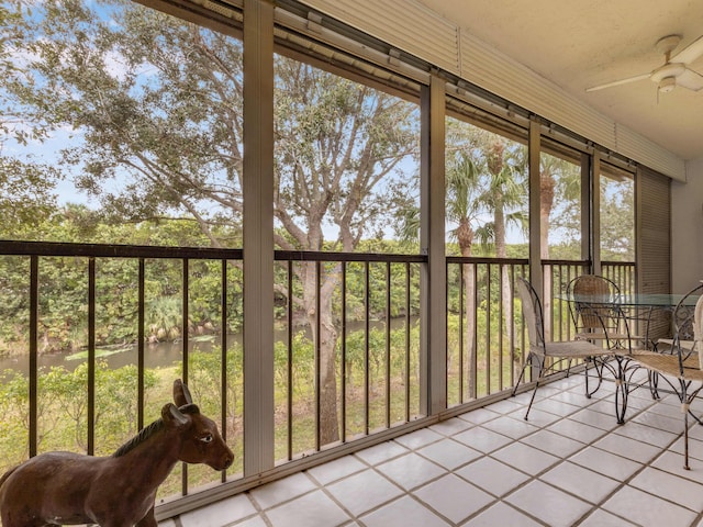 unfurnished sunroom featuring ceiling fan