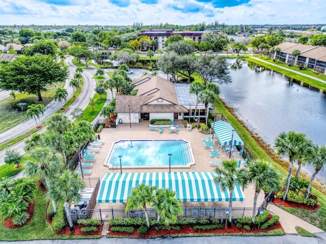 pool with a water view, fence, and a patio