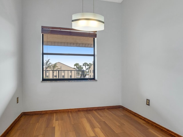 empty room featuring baseboards and wood finished floors