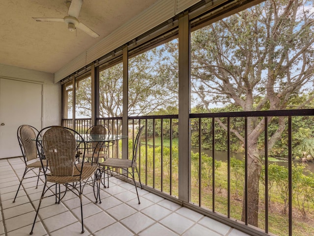 unfurnished sunroom with ceiling fan